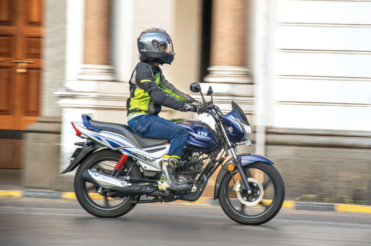 Side profile riding shot of the TVS Star City Plus 110cc commuter motorcycle.