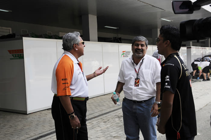 Vijay Mallya and Vicky Chandhok share a light moment in the paddock.