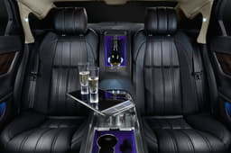 A full-length, leather-trimmed centre console separates the two individually tailored rear seats which feature power adjustment, ventilation, massage and lumbar functions. A table, machined from solid aluminium with piano-black and chrome detailing, rises up from the centre console at the touch of a button to provide a working area, its role supplemented by the provision of two third-generation iPads® with wireless keyboards that are housed in bespoke leather-trimmed docks in the rear of the front seats.