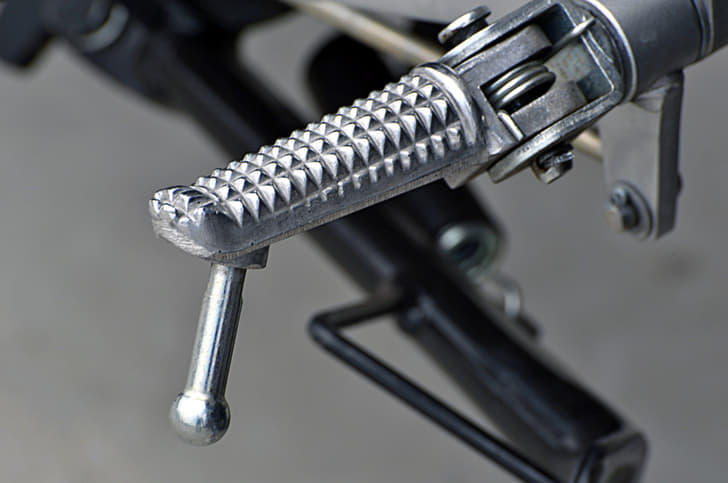 Knurled metal footpegs are grippy.