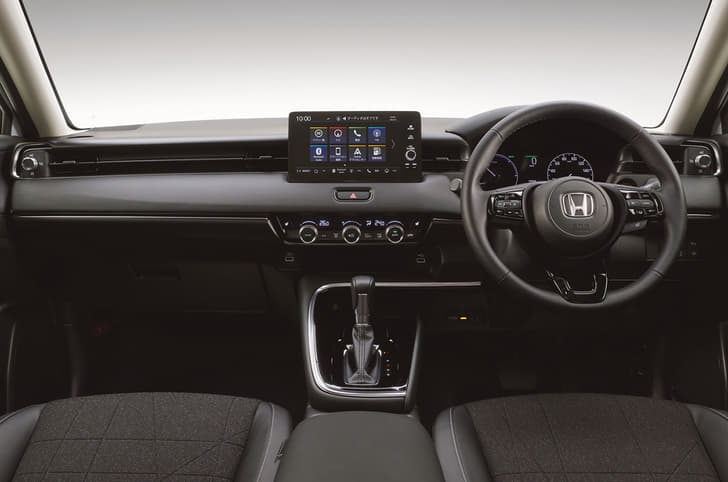 Cabin features a minimalist layout with limited control surfaces on the dash. Multi-layered dash is bisected by a swathe of leather.