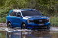 2022 Ford Everest wading through water right side view. 2022 Ford Everest wading through water right side view.