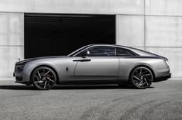 rolls royce spectre black badge side profile in front of hangar
