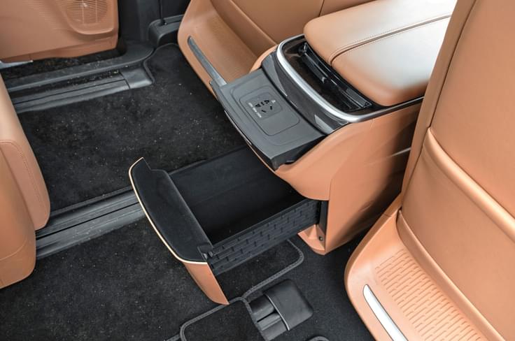 Front center console houses a massive storage compartment and 150W charging port. MG M9 rear center console storage