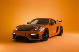 Porsche 718 Cayman GT4 RS with Manthey kit in orange exterior studio shot