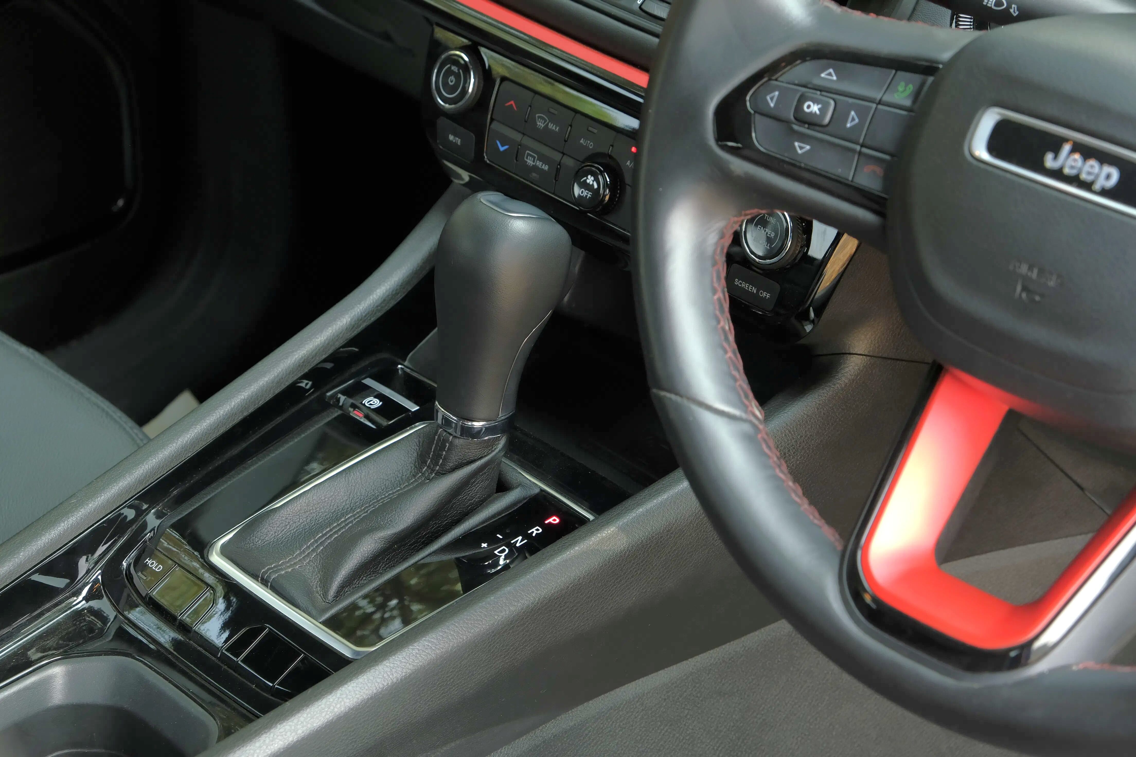 Functions like 4WD low, hill descent control, and 4WD lock sit below the gear lever in a row of buttons.